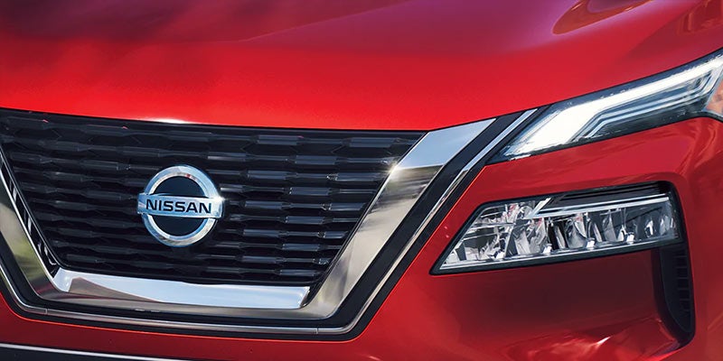 A Nissan Logo on Front bumper of Red Car