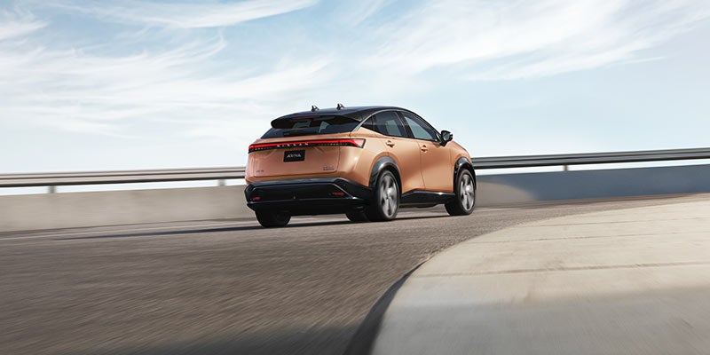 A Nissan Ariya running on the road rear view