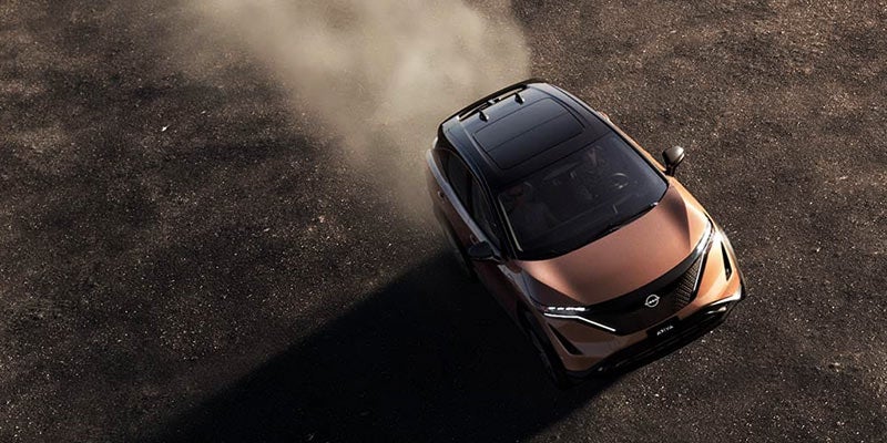 Nissan Ariya kicking up dust on a dry terrain